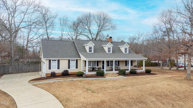 cape cod house with a front lawn and covered porch