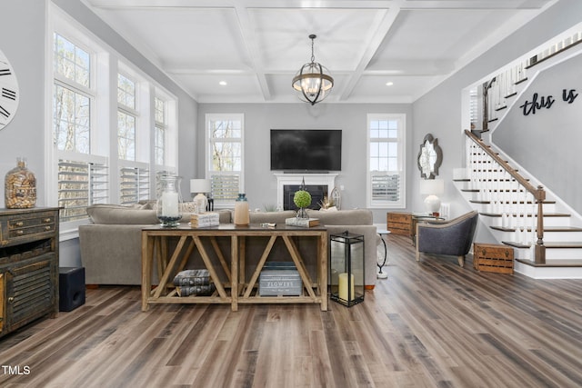 living room featuring an inviting chandelier, wood-type flooring, coffered ceiling, and beamed ceiling