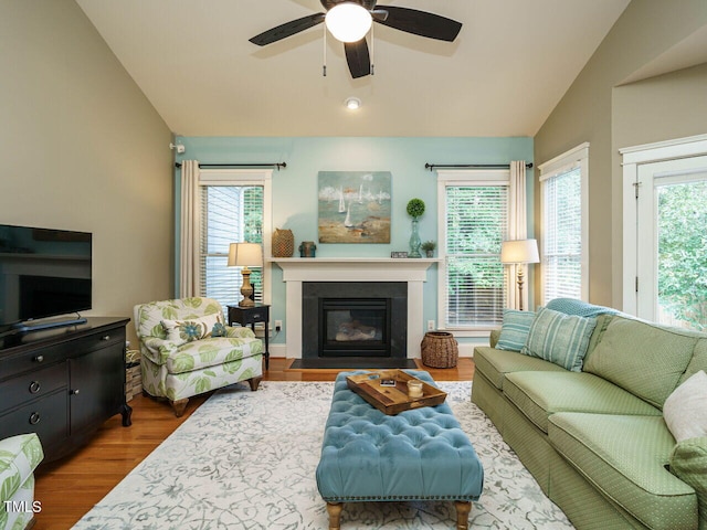 living room with ceiling fan, a healthy amount of sunlight, lofted ceiling, and hardwood / wood-style floors