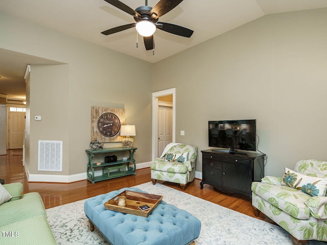 living room with ceiling fan, wood-type flooring, and vaulted ceiling