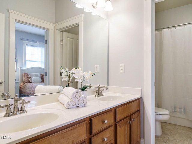 bathroom with tile patterned flooring, vanity, walk in shower, and toilet