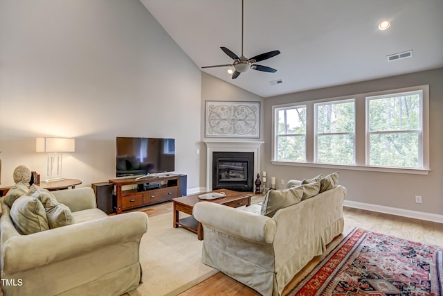 living room featuring high vaulted ceiling, light hardwood / wood-style floors, and ceiling fan