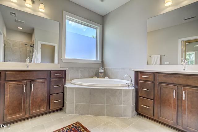 bathroom featuring independent shower and bath, vanity, and tile patterned floors