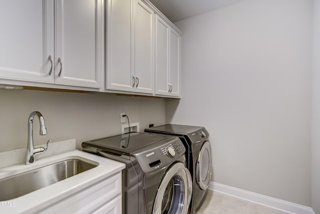 washroom with cabinets, separate washer and dryer, and sink