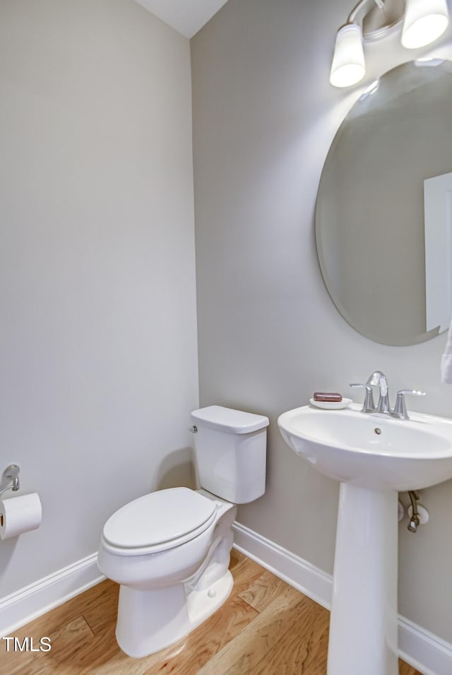 bathroom with hardwood / wood-style flooring, sink, and toilet