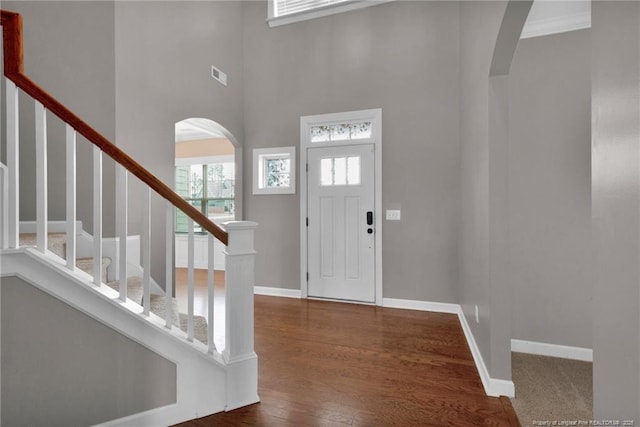 foyer featuring dark hardwood / wood-style floors and a towering ceiling