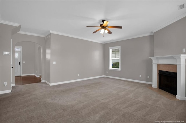 unfurnished living room featuring ceiling fan, crown molding, light colored carpet, and a fireplace