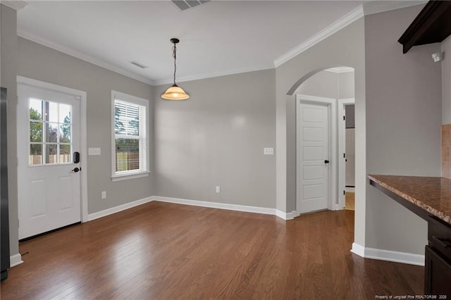 unfurnished dining area featuring dark wood-type flooring and ornamental molding