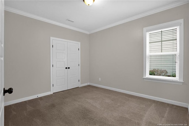 empty room with crown molding and carpet flooring