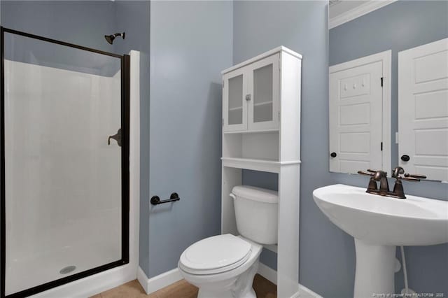 bathroom featuring sink, ornamental molding, toilet, and walk in shower