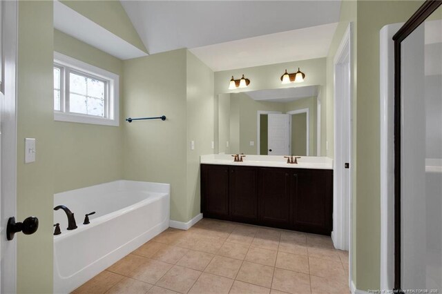 bathroom featuring lofted ceiling, a tub, tile patterned floors, and vanity