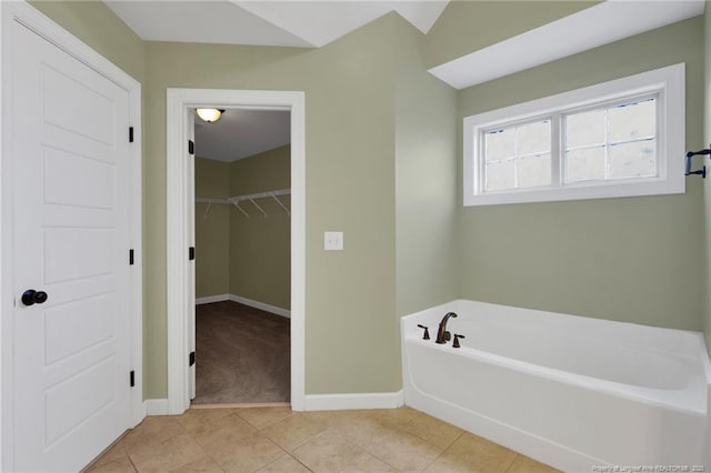 bathroom with tile patterned floors and a tub to relax in