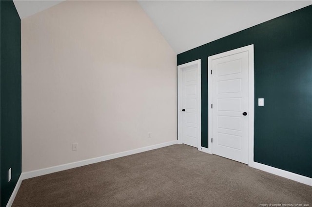 unfurnished bedroom featuring lofted ceiling and carpet