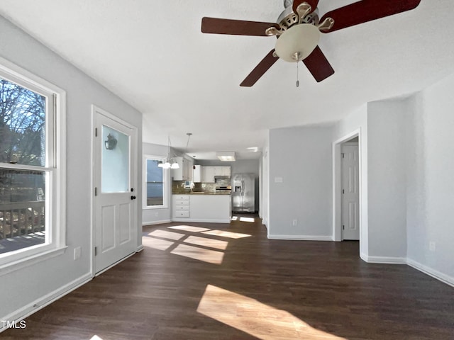 unfurnished living room with a notable chandelier and dark wood-type flooring