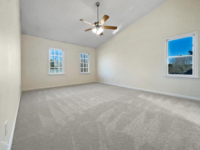 empty room with lofted ceiling, carpet flooring, and ceiling fan