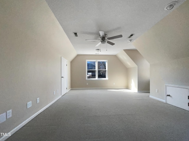 additional living space with ceiling fan, lofted ceiling, carpet, and a textured ceiling