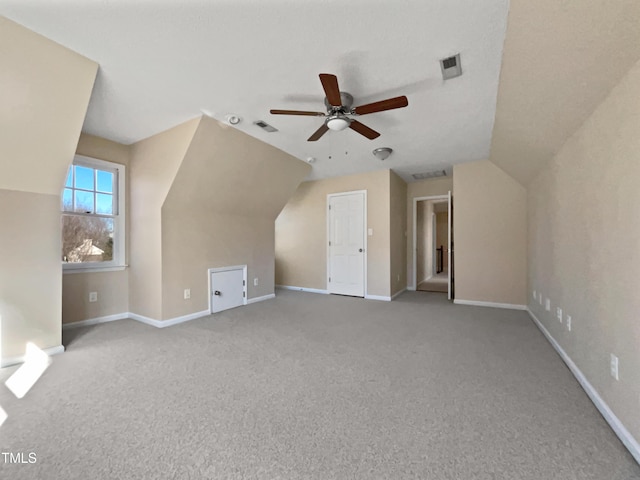 additional living space featuring ceiling fan, light colored carpet, and lofted ceiling