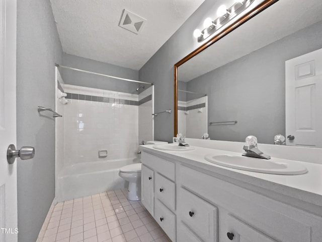 full bathroom featuring tile patterned flooring, tiled shower / bath combo, vanity, a textured ceiling, and toilet