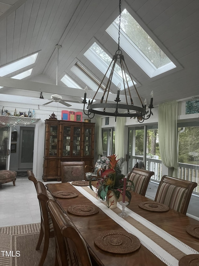 sunroom featuring an inviting chandelier and lofted ceiling with skylight