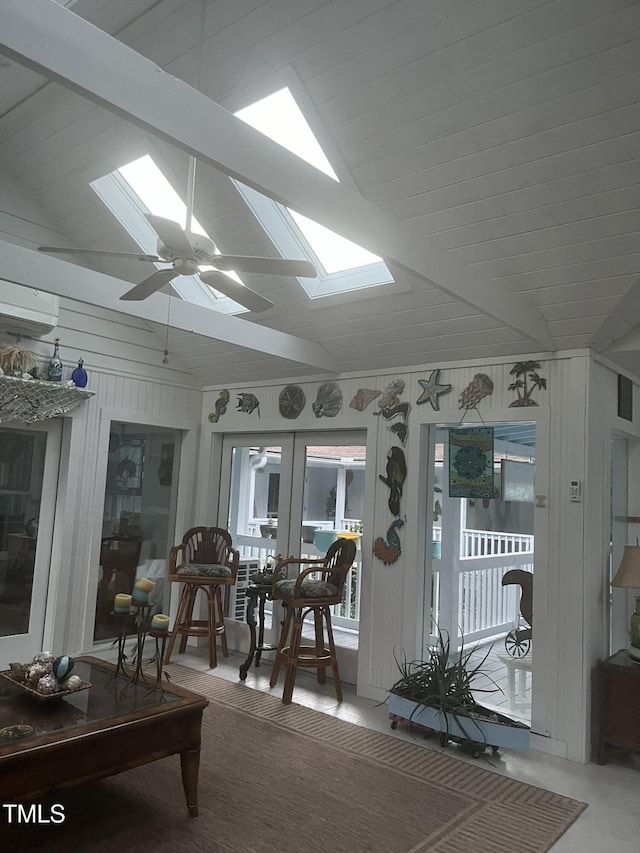 sunroom featuring lofted ceiling with skylight, ceiling fan, and french doors