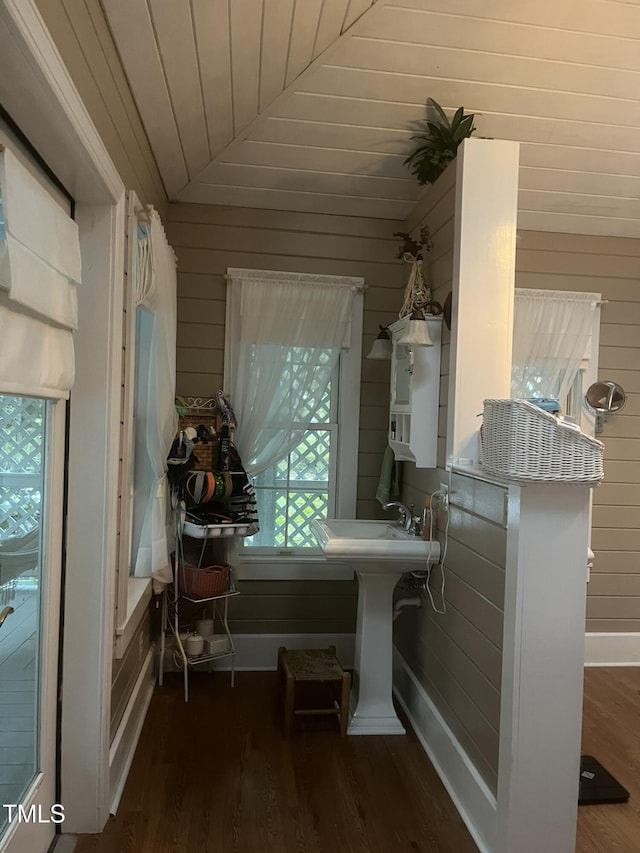 interior space with lofted ceiling, sink, wooden walls, wood-type flooring, and wooden ceiling