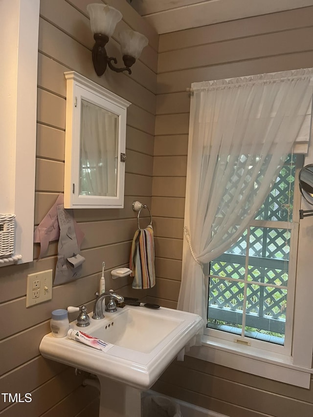 bathroom with sink and wood walls