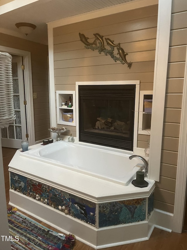 bathroom with wood-type flooring, a bathing tub, and wood walls