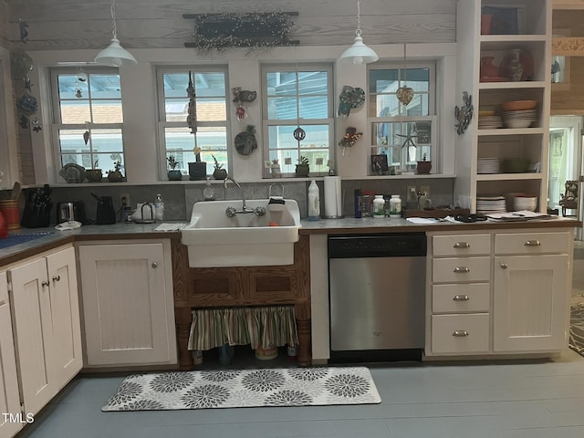 kitchen featuring dishwasher, sink, hanging light fixtures, and white cabinets