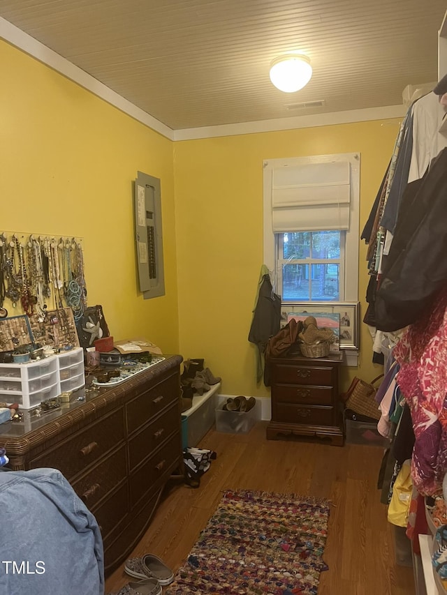 bedroom featuring hardwood / wood-style flooring, ornamental molding, and electric panel