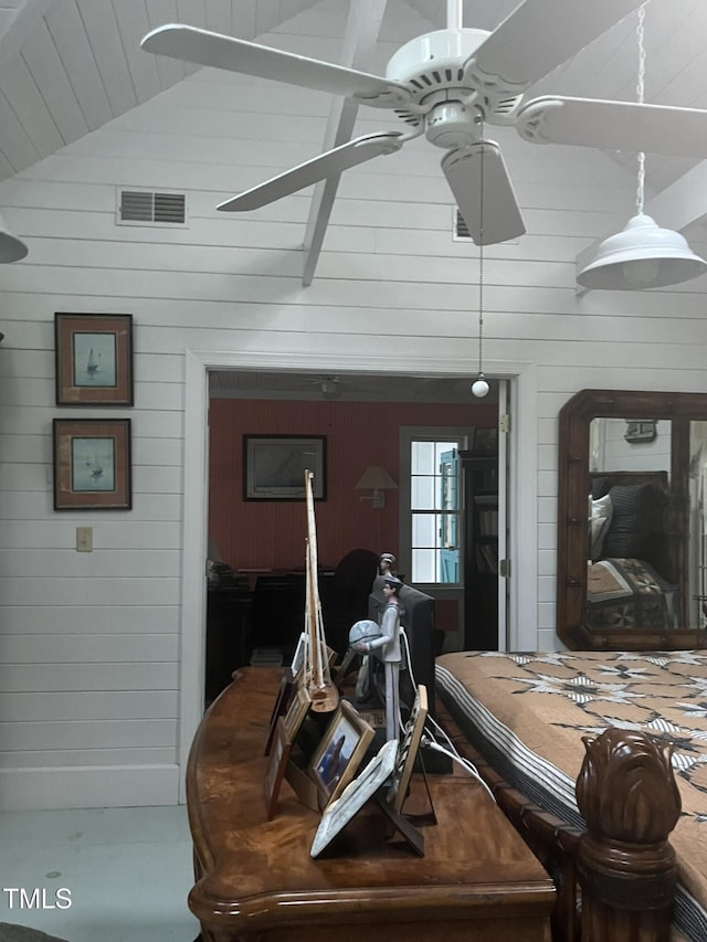 bedroom featuring vaulted ceiling and wooden walls