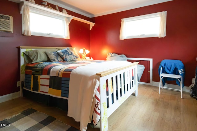 bedroom featuring hardwood / wood-style floors and an AC wall unit