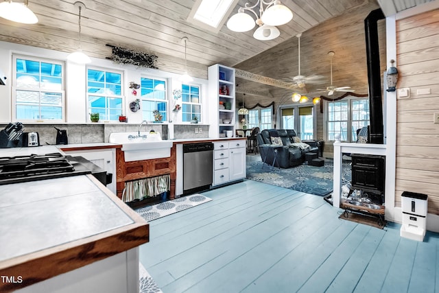 kitchen with appliances with stainless steel finishes, decorative light fixtures, a wood stove, wood ceiling, and light hardwood / wood-style flooring