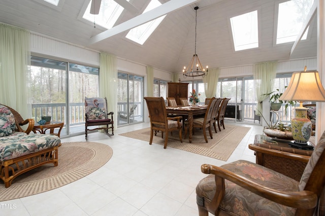 tiled dining space with high vaulted ceiling, a chandelier, and a skylight