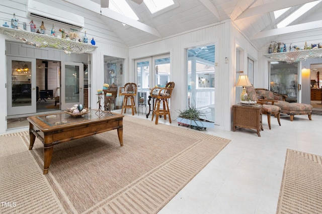 sunroom with ceiling fan, vaulted ceiling with skylight, a wall mounted AC, and a wood stove