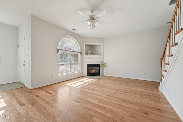 unfurnished living room featuring ceiling fan and light wood-type flooring