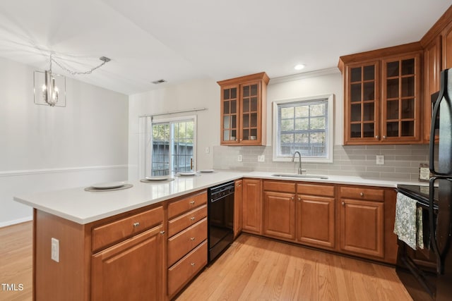 kitchen featuring pendant lighting, sink, black appliances, and kitchen peninsula