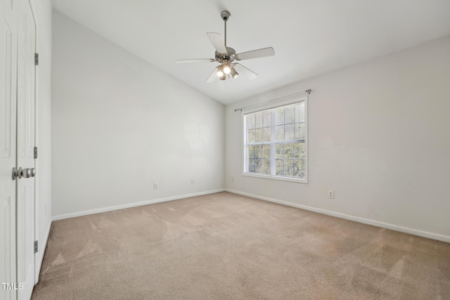 spare room featuring vaulted ceiling, light colored carpet, and ceiling fan