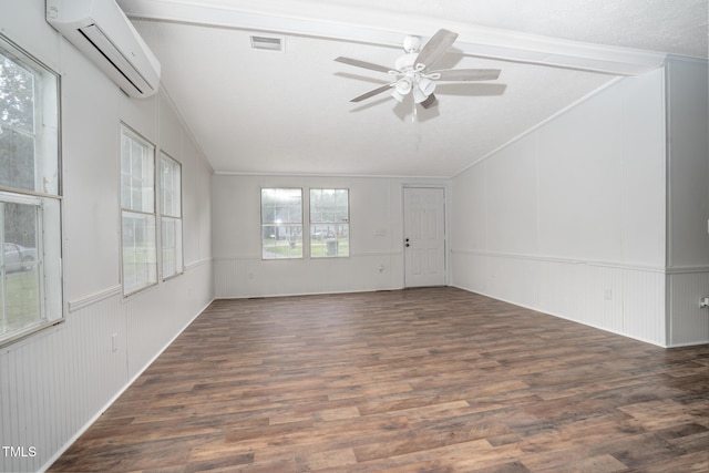 spare room featuring dark wood-type flooring, crown molding, a wall mounted air conditioner, a textured ceiling, and ceiling fan