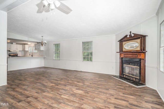 unfurnished living room with vaulted ceiling, dark hardwood / wood-style flooring, sink, and a textured ceiling