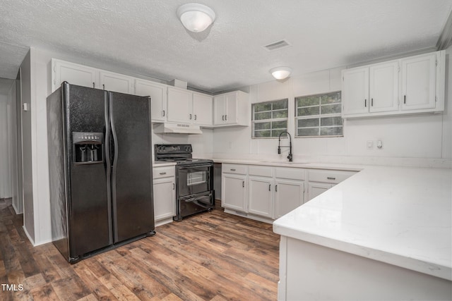 kitchen with white cabinets, dark hardwood / wood-style flooring, sink, and black appliances