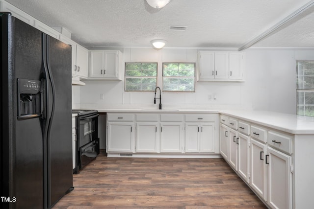 kitchen with white cabinetry, sink, kitchen peninsula, and black appliances