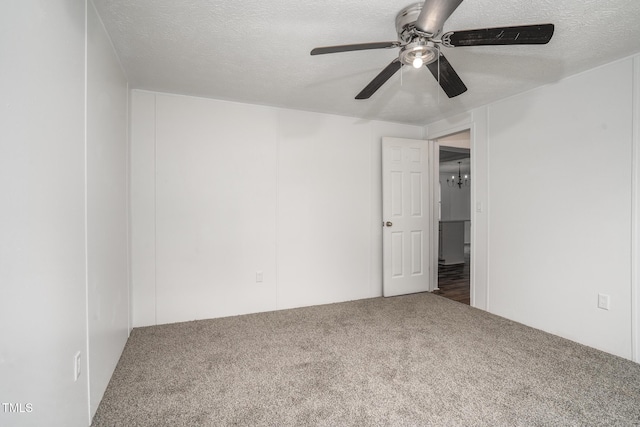 carpeted empty room featuring ceiling fan and a textured ceiling