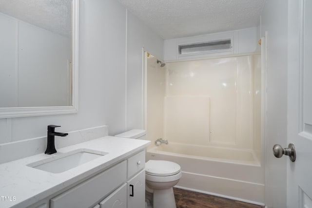 full bathroom with vanity,  shower combination, toilet, and a textured ceiling