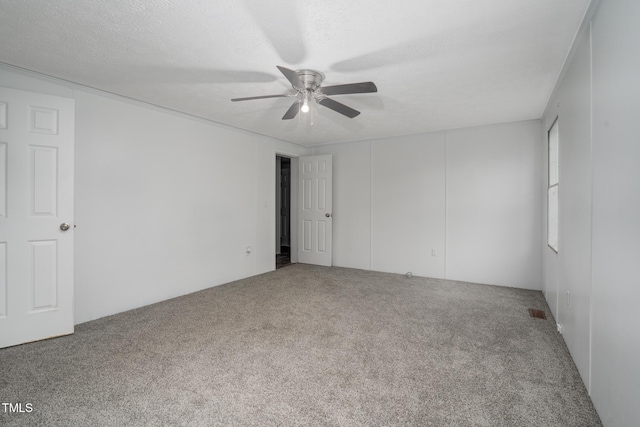 unfurnished room with ceiling fan, carpet floors, and a textured ceiling