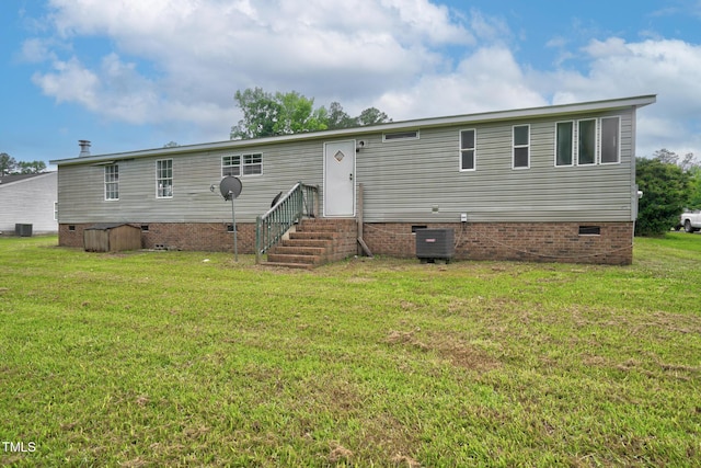 back of property with a yard and central air condition unit