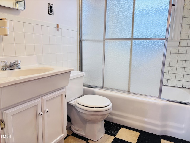 full bathroom featuring tile walls, vanity, shower / bath combination with glass door, and toilet