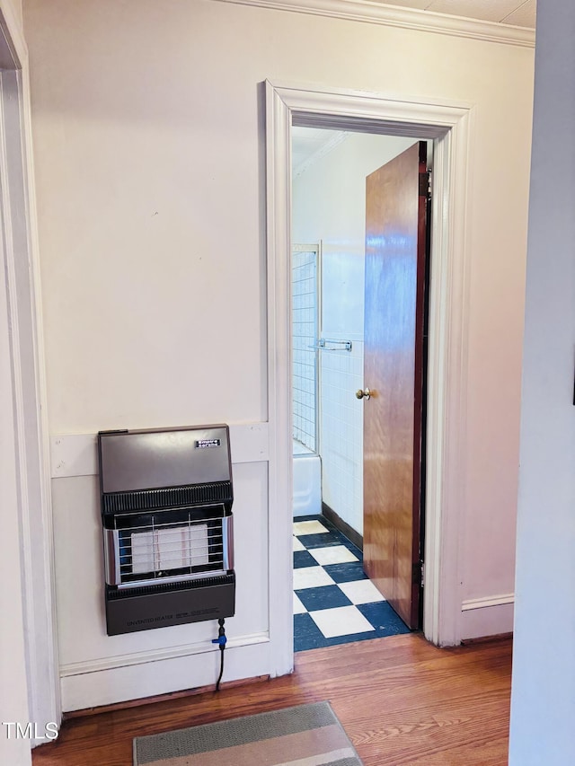 corridor featuring crown molding, heating unit, and light hardwood / wood-style flooring