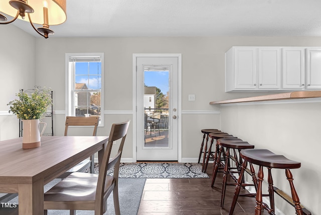 dining space featuring dark hardwood / wood-style flooring and a chandelier