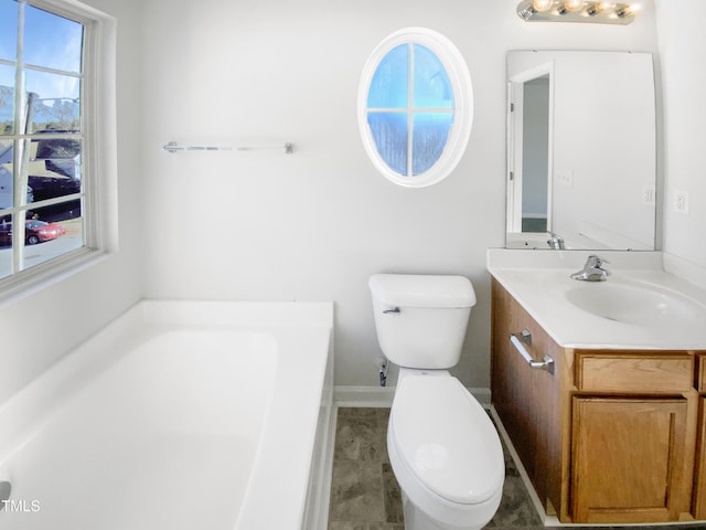 bathroom with vanity, a tub, and toilet