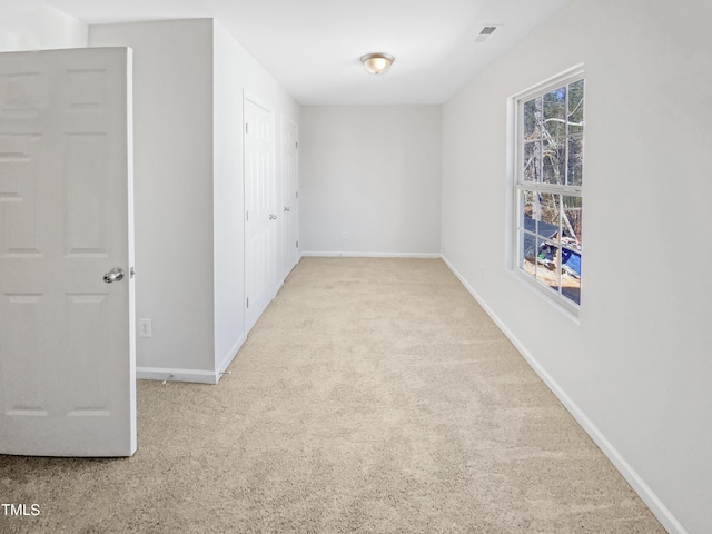 spare room featuring light colored carpet